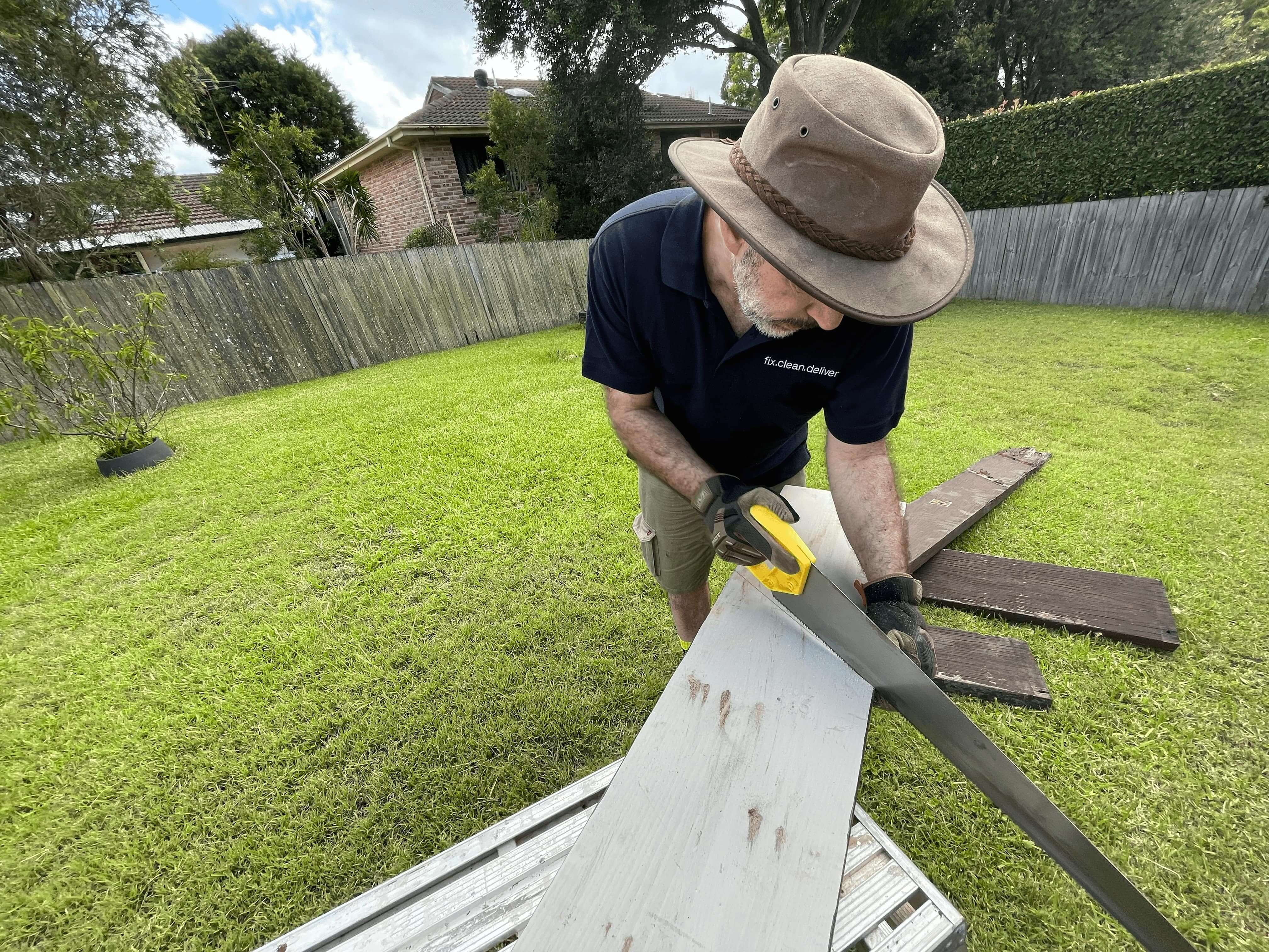 Andrew Mereau cutting wood in a backyard